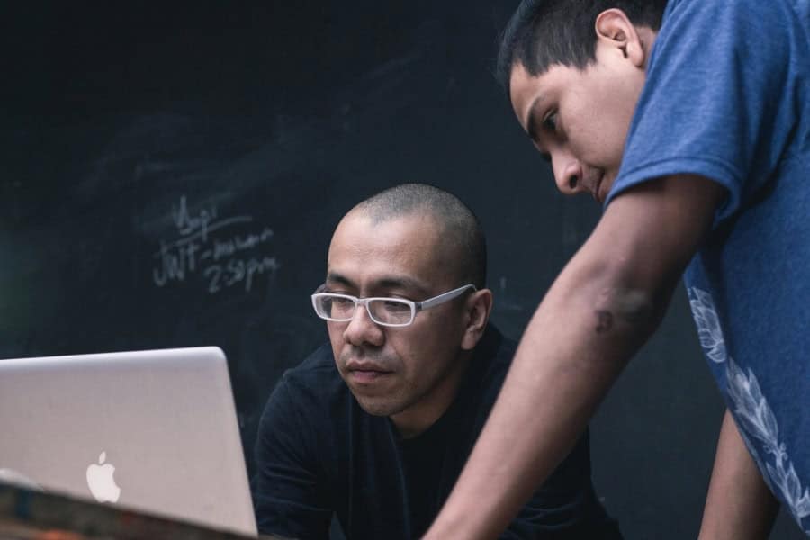 Two men collaborating over a laptop discussing Cincinnati managed IT solutions.