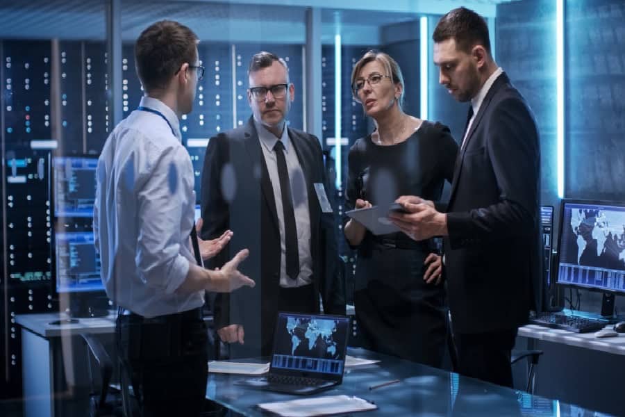A Team discusses Indianapolis manufacturing IT solutions in a high-tech server room.