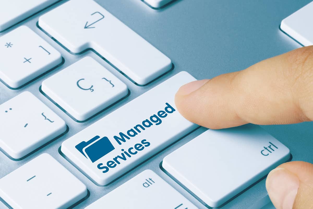 A finger pressing a keyboard button for Indianapolis managed services.