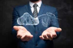A businessman is holding out his hands underneath a 3d render of a hand touching a cloud.