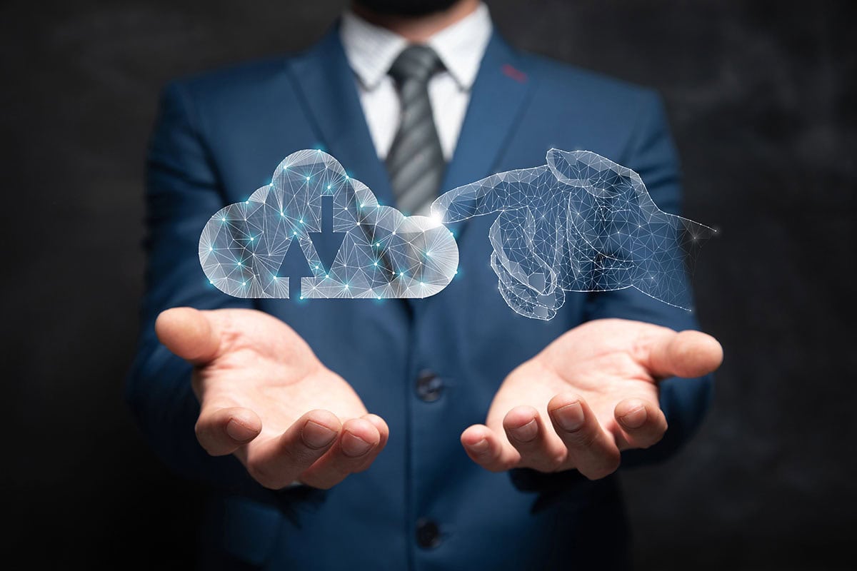 A businessman is holding out his hands underneath a 3d render of a hand touching a cloud.