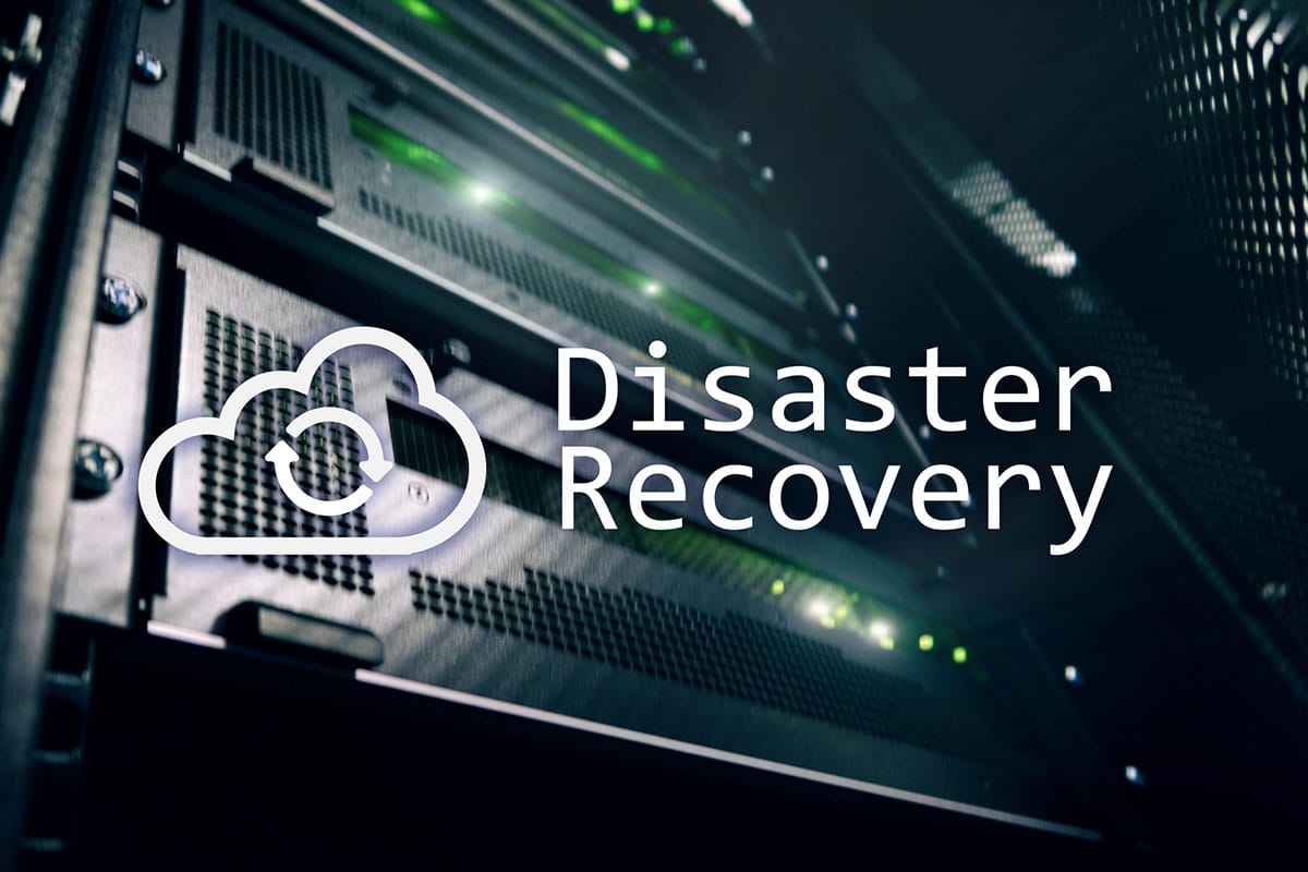A graphic of a cloud with the text "Disaster Recovery" is overlaid on a close-up shot of of a server rack in a data center.