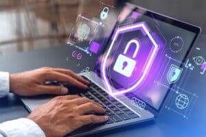 A man is using a laptop with a graphic of a padlock and other security icons.