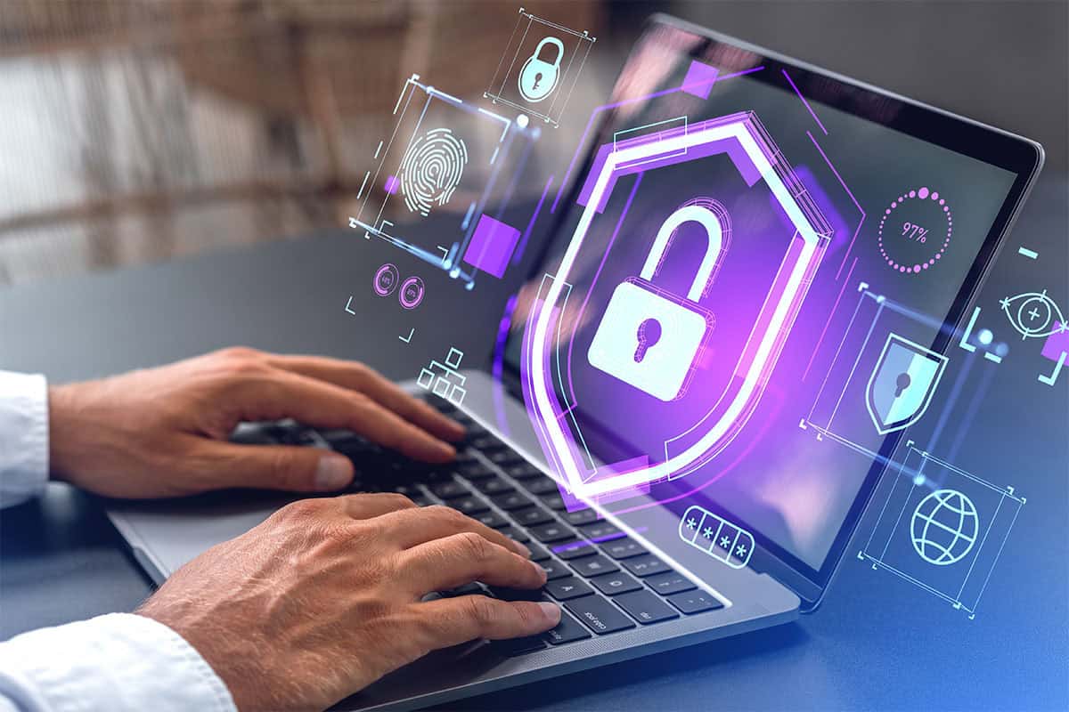 A man is using a laptop with a graphic of a padlock and other security icons.