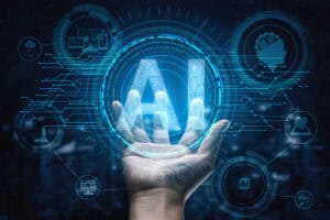 A hand reaching out towards a glowing, blue "AI" symbol, surrounded by digital graphics representing artificial intelligence and technology, including gears, data charts, and a robotic figure, all set against a dark background.
